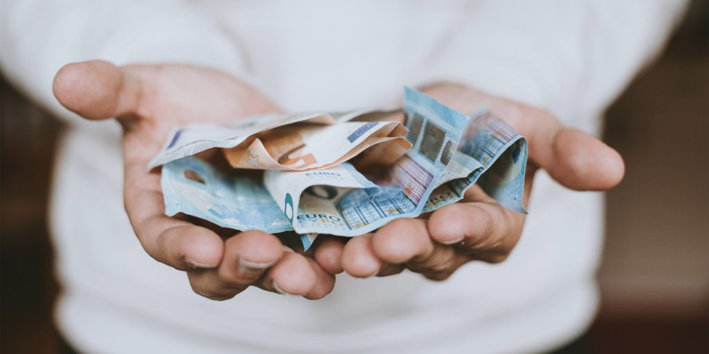 Open hands holding a selection of currency 